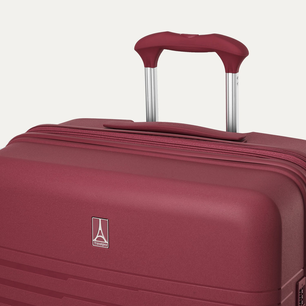 Maroon suitcase with handle on a white background
