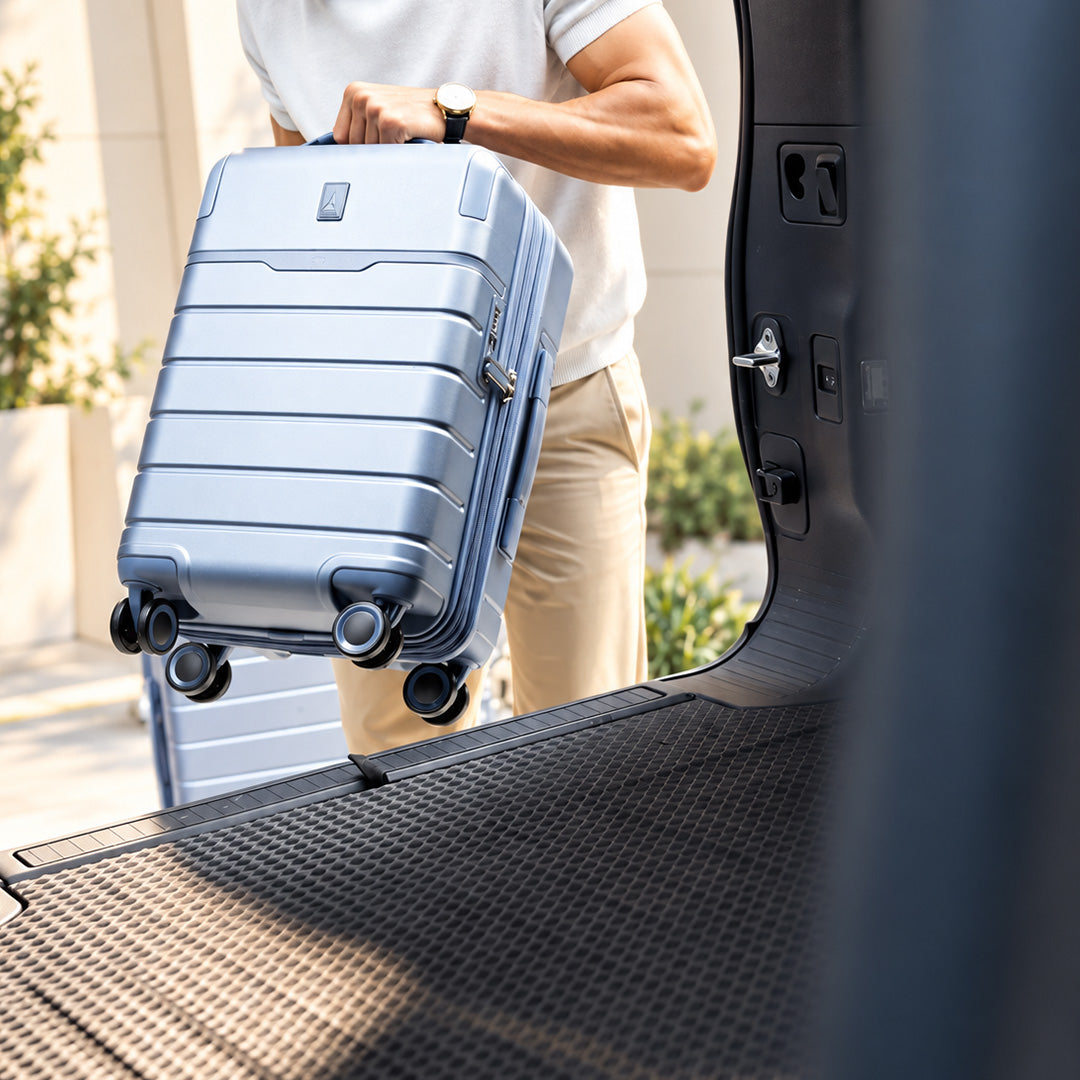 Traveller lifting a Steel Blue Platinum Reserve carry-on into a car